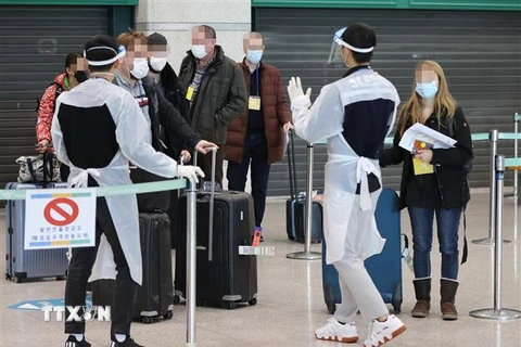 Nhân viên kiểm dịch hướng dẫn hành khách đến từ châu Âu tại sân bay quốc tế Incheon, phía tây thủ đô Seoul, Hàn Quốc, ngày 7/1/2021. (Ảnh: Yonhap/ TTXVN)
