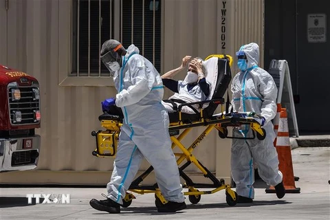 Nhân viên y tế chuyển bệnh nhân mắc COVID-19 vào một bệnh viện ở Miami, Mỹ ngày 30/7/2020. (Ảnh: AFP/TTXVN)
