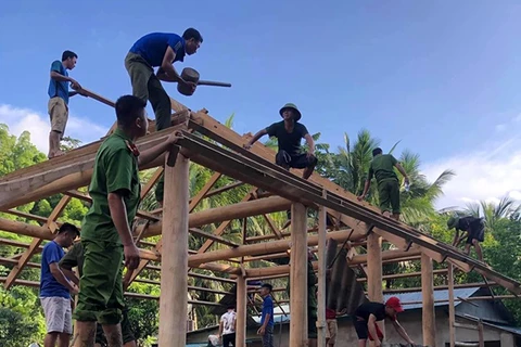 Đoàn viên thanh niên tình nguyện huyện Quan Sơn, tỉnh Thanh Hóa phối hợp với lực lượng vũ trang giúp người dân bản Sa Ná, xã Na Mèo dựng lại nhà cửa sau lũ. (Ảnh: TTXVN phát)