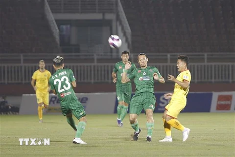 Pha tranh bóng giữa các cầu thủ đội chủ nhà Sài Gòn FC (áo xanh) và SLNA (áo vàng). (Ảnh: Thanh Vũ/TTXVN)