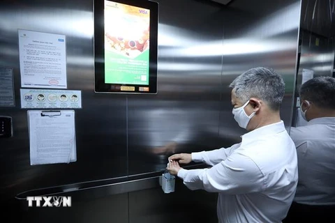 Dung dịch sát khuẩn luôn được để sẵn trong các thang máy tại các khu chung cư. (Ảnh: Phan Tuấn Anh/TTXVN)