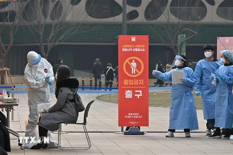 Nhân viên y tế lấy mẫu xét nghiệm COVID-19 cho người dân tại Seoul, Hàn Quốc ngày 23/12/2020. (Ảnh: AFP/TTXVN)