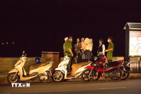 Lực lượng chức năng của thành phố Vũng Tàu, tỉnh Bà Rịa-Vũng Tàu xử lý các trường hợp người dân không đeo khẩu trang nơi công cộng đêm 9/2. (Ảnh: Kha San/TTXVN)