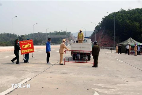 Lực lượng chức năng gỡ bỏ trang thiết bị tại chốt kiểm dịch Trạm thu phí cao tốc Vân Đồn-Hạ Long. (Ảnh: TTXVN phát)