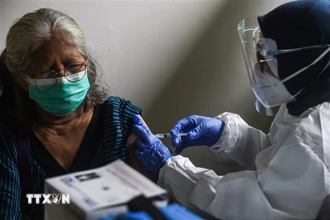 Nhân viên y tế tiêm vắcxin phòng COVID-19 cho người dân tại Jakarta, Indonesia, ngày 24/2/2021. (Ảnh: THX/TTXVN)