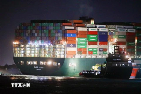 Tàu cứu hộ nỗ lực giải cứu siêu tàu container Ever Given bị mắc cạn tại kênh đào Suez, Ai Cập, ngày 27/3/2021. (Ảnh: THX/TTXVN)