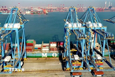 Bốc dỡ hàng hóa tại cảng Thanh Đảo, tỉnh Sơn Đông, Trung Quốc, ngày 19/2/2021. (Ảnh: THX/ TTXVN)