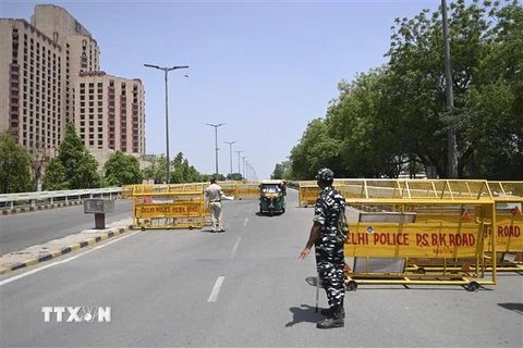 Cảnh sát dựng chốt chặn tại một tuyến phố ở New Delhi, Ấn Độ khi lệnh phong tỏa được áp đặt nhằm ngăn chặn sự lây lan của dịch COVID-19, ngày 18/4/2021. (Ảnh: AFP/TTXVN)
