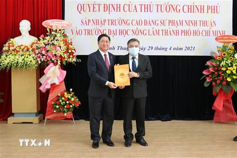 Chủ tịch UBND tỉnh Ninh Thuận Trần Quốc Nam (trái) trao Quyết định của Thủ tướng Chính phủ sáp nhập Trường Cao đẳng sư phạm Ninh Thuận vào Trường Đại học Nông Lâm Thành phố Hồ Chí Minh. (Ảnh: Công Thử/TTXVN)