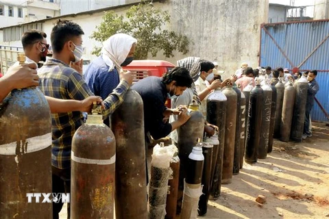 Người dân xếp hàng chờ bơm đầy bình oxy để cung cấp cho bệnh nhân COVID-19 tại Patna, Ấn Độ, ngày 27/4/2021. (Ảnh: THX/TTXVN)