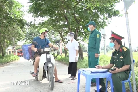 Chốt kiểm soát tiến hành đo thân nhiệt và yêu cầu người dân khai báo y tế tại Hưng Yên. (Ảnh: Đinh Tuấn/TTXVN)