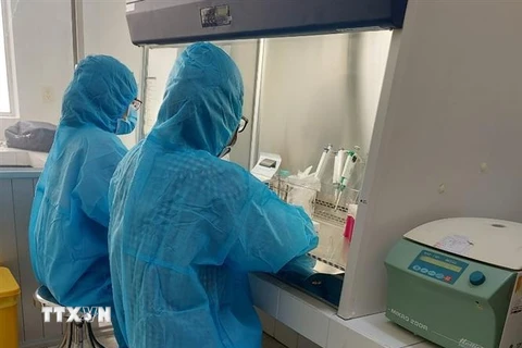 Nhân viên y tế chạy thử nghiệm máy xét nghiệm COVID-19 tại cơ sở xét nghiệm mới - Trung tâm kiểm soát bệnh tật tỉnh Long An. (Ảnh: Đức Hạnh/TTXVN)