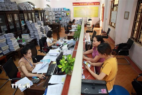 Hỗ trợ khai báo, nộp hồ sơ thuế tại bộ phận một cửa tại Chi cục Thuế khu vực Phổ Yên - Phú Bình. (Ảnh: Danh Lam/TTXVN)