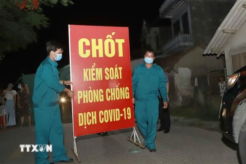 Lực lượng chức năng tiến hành tthu dọn vật dụng tại chốt cách ly tại thôn Tiền Phong, xã Tân Phong, huyện Bình Xuyên, Vĩnh Phúc. (Ảnh: Hoàng Hùng/TTXVN)