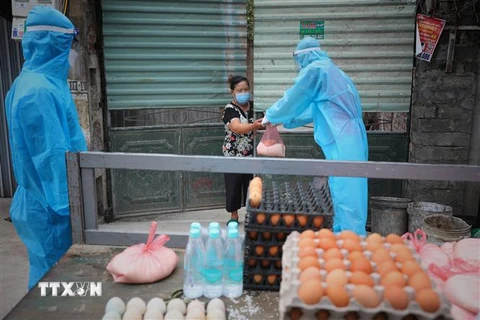 Tổ xung kích Đoàn thanh niên huyện Việt Yên, Bắc Giang hàng ngày chở lương thực tới từng nhà ở thôn Trung Đồng, xã Vân Trung, nơi người dân không được ra khỏi nhà vì bị cách ly. (Ảnh: Danh Lam/TTXVN)