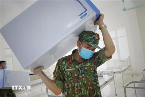 Các chiến sỹ Trung đoàn bộ binh 2, Sư đoàn bộ binh 3, Quân khu 1vận chuyển trang thiết bị cho bệnh viện dã chiến. (Ảnh: Danh Lam/TTXVN)