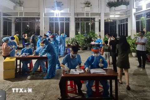 Lực lượng y tế lấy mẫu xét nghiệm COVID-19 cho người dân phường 15, quận Gò Vấp trong đêm 28/5, rạng sáng 29/5. (Ảnh: TTXVN phát)