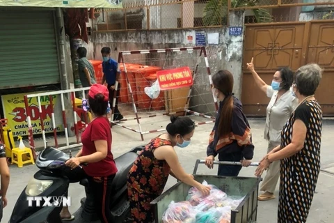 Các tổ chức, đoàn thể cung cấp nhu yếu phẩm cho người dân trong khu vực cách ly tại hẻm 637/37 Quang Trung, quận Gò Vấp, Tp.Hồ Chí Minh. (Ảnh: Anh Tuấn/TTXVN)