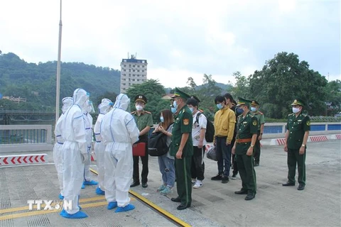 Lực lượng chức năng Việt Nam trao trả các công dân nhập cảnh trái phép cho phía Trung Quốc, tại Cửa khẩu đường bộ quốc tế Lào Cai. (Ảnh: TTXVN phát)