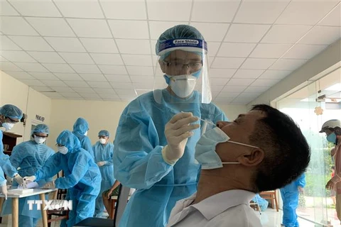 Nhân viên y tế lấy mẫu xét nghiệm COVID-19 cho người dân tại khu phố 1, phường 15, quận Gò Vấp, ngày 29/5. (Ảnh: TTXVN phát)