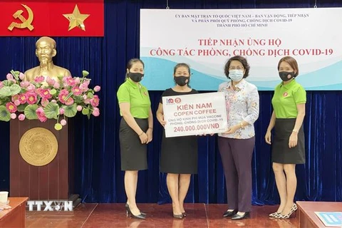 Bà Tô Thị Bích Châu, Chủ tịch Ủy ban MTTQ Việt Nam Thành phố Hồ Chí Minh (giữa) tiếp nhận kinh phí ủng hộ mua vaccine phòng, chống COVID-19 từ đại diện các doanh nghiệp, tổ chức. (Ảnh: Xuân Khu/TTXVN)