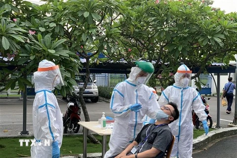 Các y, bác sỹ Trung tâm kiểm soát bệnh tật Tp Hồ Chí Minh và Quận 7 thực hiện xét nghiệm sàng lọc COVID-19 ngẫu nhiên cho công nhân ở Khu chế xuất Tân Thuận. (Ảnh: Thanh Vũ/TTXVN)