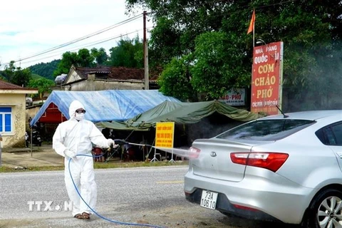 Phương tiện được phun khử khuẩn tại chốt kiểm soát dịch bệnh COVID-19 trên đường Hồ Chí Minh địa phận xã Hương Hóa, huyện Tuyên Hóa, tỉnh Quảng Bình. (Ảnh: TTXVN phát)