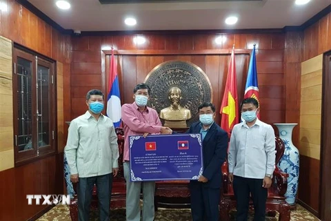 Đại diện Chính quyền tỉnh Bokeo trao tặng tiền hỗ trợ 3 tỉnh của Việt Nam phòng, chống dịch COVID-19. (Ảnh: TTXVN phát)