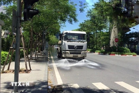 Công ty TNHH MTV Môi trường Đô thị Hà Nội, Chi nhánh Đống Đa thực hiện tưới nước làm mát, giảm bụi tại tuyến đường Hoàng Cầu (Đống Đa) trong những ngày nắng nóng. (Ảnh Minh Nghĩa/TTXVN)