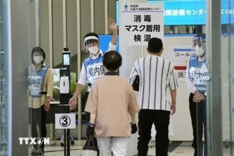 Người dân đi tiêm vaccine ngừa COVID-19 tại một điểm tiêm chủng ở Osaka, Nhật Bản, ngày 14/6/2021. (Ảnh: Kyodo/TTXVN)