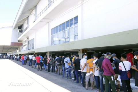 Rất đông người dân thủ đô Vientiane đang kiên nhẫn xếp hàng chờ đến lượt tiêm vaccine ngừa COVID-19. (Ảnh: Phạm Kiên/Vietnam+) 