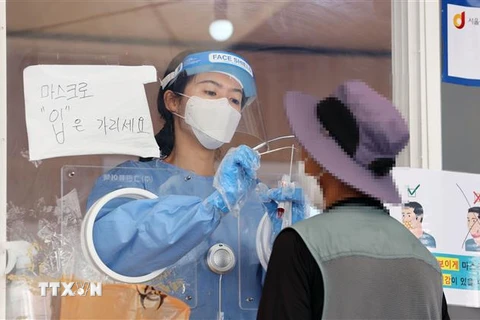 Nhân viên y tế lấy mẫu xét nghiệm COVID-19 cho người dân tại Seoul, Hàn Quốc. (Ảnh: YONHAP/TTXVN)