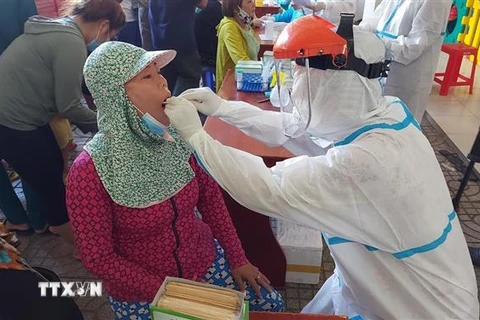 Các cán bộ y tế tiến hành lấy mẫu xét nghiệm COVID cho người dân xã Phước Tỉnh, huyện Long Điền, tỉnh Bà Rịa-Vũng Tàu vào chiều ngày 30/6. (Ảnh: Hoàng Nhị/TTXVN)