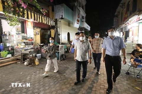 Đoàn kiểm tra kiểm tra đột xuất một số nhà hàng ăn uống trên phố ẩm thực Tống Duy Tân, phường Hàng Bông, quận Hoàn Kiếm. (Ảnh: Minh Quyết/TTXVN)