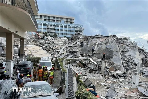 Lực lượng cứu hộ làm nhiệm vụ tại hiện trường vụ sập tòa nhà ở thành phố Surfside, bang Florida, Mỹ, ngày 25/6/2021. (Ảnh: AFP/TTXVN)