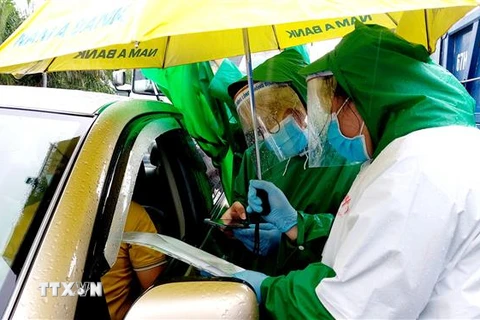 Lực lượng tình nguyện viên kiểm tra giấy xét nghiệm SARS-CoV-2 xe vào địa phận thành phố Cần Thơ. (Ảnh: Thu Hiền/TTXVN)