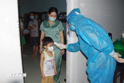 Cán bộ và nhân viên y tế kiểm tra và đo thân nhiệt cho người đang cách ly tại Bạc Liêu. (Ảnh: Chanh Đa/TTXVN)
