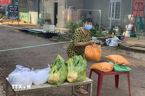 Người dân tại vực chợ Đắk Ơ (xã Đắk Ơ, huyện Bù Gia Mập, tỉnh Bình Phước) nhận thực phẩm miễn phí. (Ảnh: TTXVN phát)