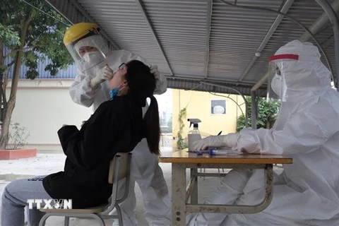 Nhân viên y tế lấy mẫu người có tiếp xúc gần tại Hà Nội. (Ảnh: Phạm Hùng/TTXVN phát)