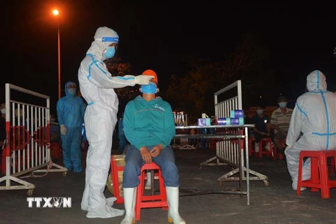 Nhân viên y tế lấy mẫu xét nghiệm cho người dân Cảng cá Thọ Quang vào tháng 5. (Ảnh: Văn Dũng/TTXVN)
