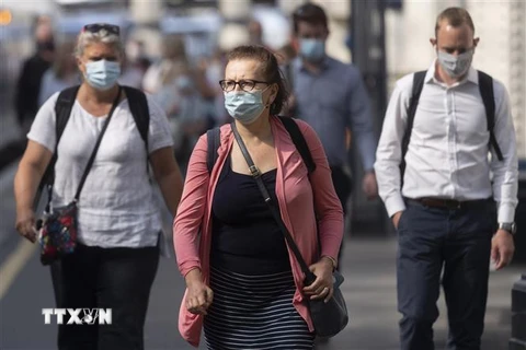 Người dân đeo khẩu trang phòng dịch COVID-19 khi đi trên đường phố ở London, Anh ngày 19/7/2021. (Ảnh: THX/TTXVN)