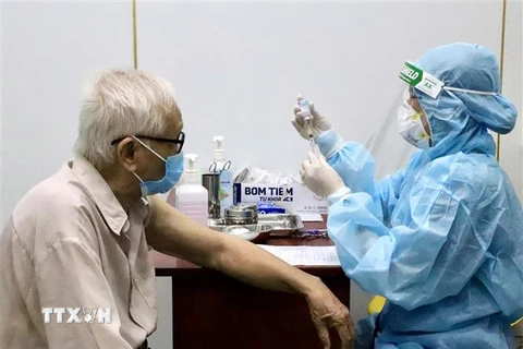 Các y bác sỹ Trung tâm Y tế Quận 11, Tp. Hồ Chí Minh tiêm vaccine Moderna phòng COVID-19 trong đợt 5 cho người trên 65 tuổi, người mắc bệnh mãn tính, người thuộc diện chính sách, có công. (Ảnh: Hồng Giang/TTXVN)
