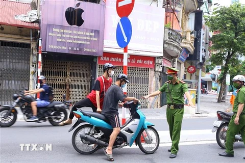 Công an phường Bạch Mai (quận Hai Bà Trưng) kiểm tra những người ra đường, sáng 26/7. (Ảnh: Hoàng Hiếu/TTXVN)