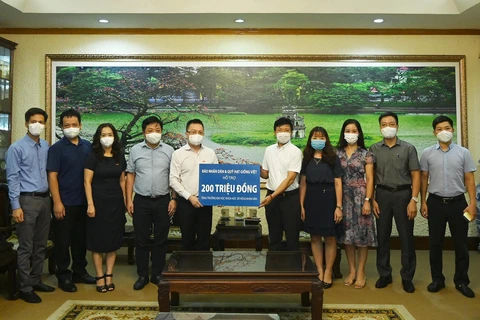 Tổng Biên tập Báo Nhân Dân Lê Quốc Minh trao quà hỗ trợ Trường đại học Khoa học Xã hội và Nhân văn. (Ảnh: Duy Linh)
