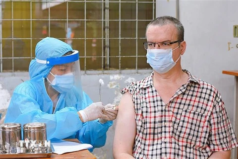 Người nước ngoài sinh sống, học tập, làm việc tại Thành phố Hồ Chí Minh tiêm vaccine trong đợt tiêm vaccine đầu tháng 8. (Ảnh: Xuân Khu/TTXVN)