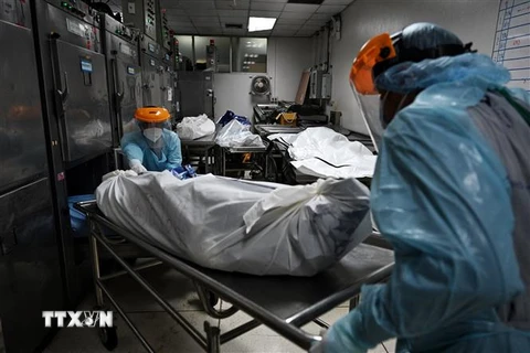 Nhân viên y tế chuyển thi thể bệnh nhân COVID-19 tại nhà xác bệnh viện Thammasat ở tỉnh Pathum Thani, ngoại ô Bangkok, Thái Lan ngày 4/8. (Ảnh: AFP/TTXVN)