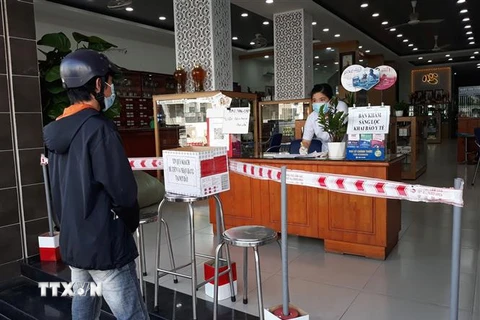 Người dân thành phố Phan Rang-Tháp Chàm tuân thủ các biện pháp phòng, chống dịch COVID-19 khi đi đến nhà thuốc. (Ảnh: Nguyễn Thành/TTXVN)