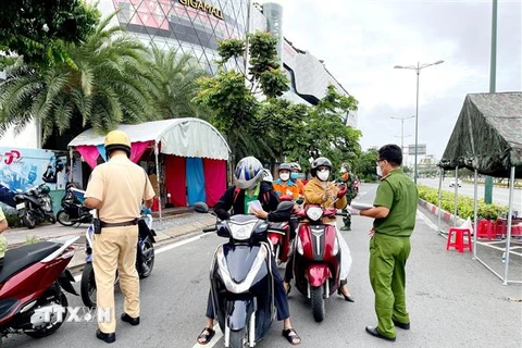 Lực lượng Công an tại chốt kiểm trên đường Phạm Văn Đồng (phường Hiệp Bình Chánh, Thủ Đức) kiểm tra giấy tờ của người lưu thông. (Ảnh: Thành Chung/TTXVN)