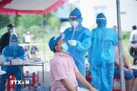 Đội thanh niên tình nguyện thuộc Tỉnh đoàn Bình Dương hỗ trợ ngành y tế lấy mẫu xét nghiệm tại "vùng đỏ" của 15 phường trên địa bàn thành phố Thuận An, Dĩ An và thị xã Tân Uyên. (Ảnh: Chí Tưởng/TTXVN)