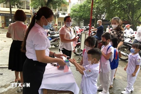 Học Trường Tiểu học Minh Khai, thành phố Hà Giang được do thân nhiệt và sát khuẩn trước khi vào lớp. (Ảnh: Nguyễn Chiến/TTXVN)